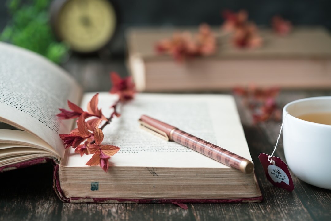 Open notebook with handwritten notes and a cup of tea