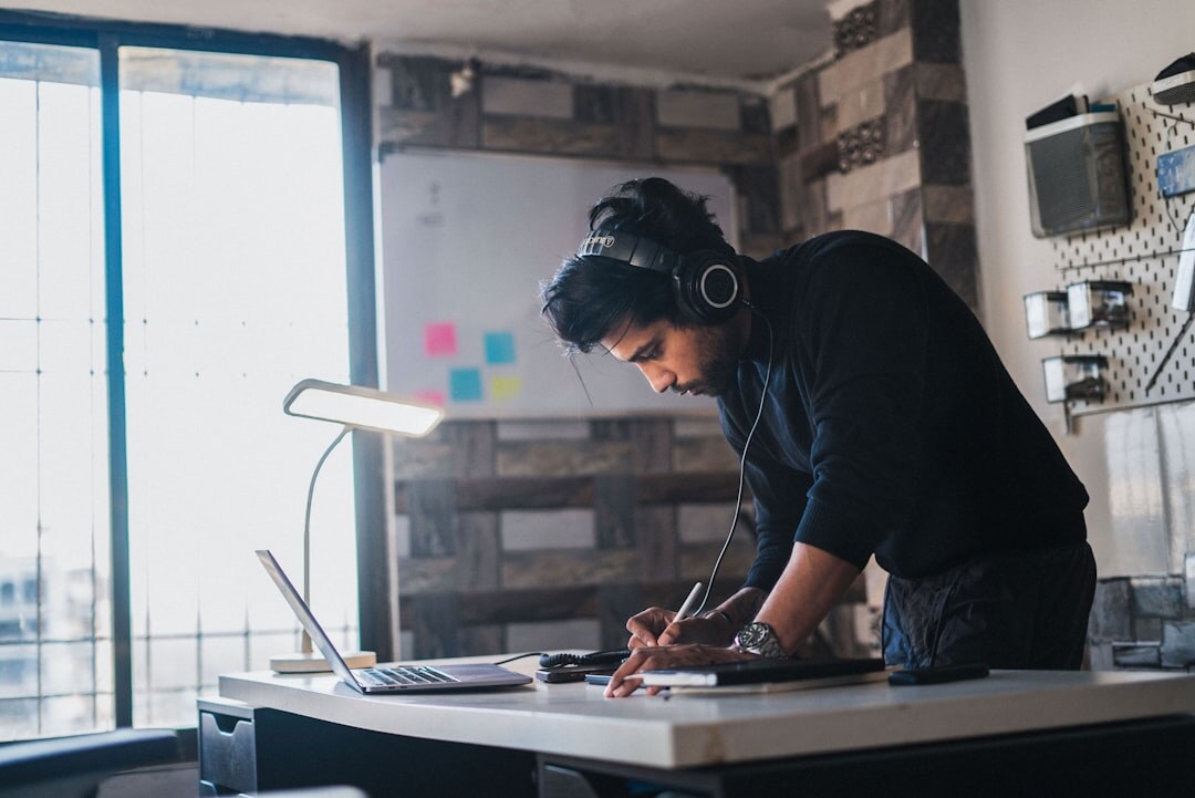 Person reading and taking notes at a bright desk